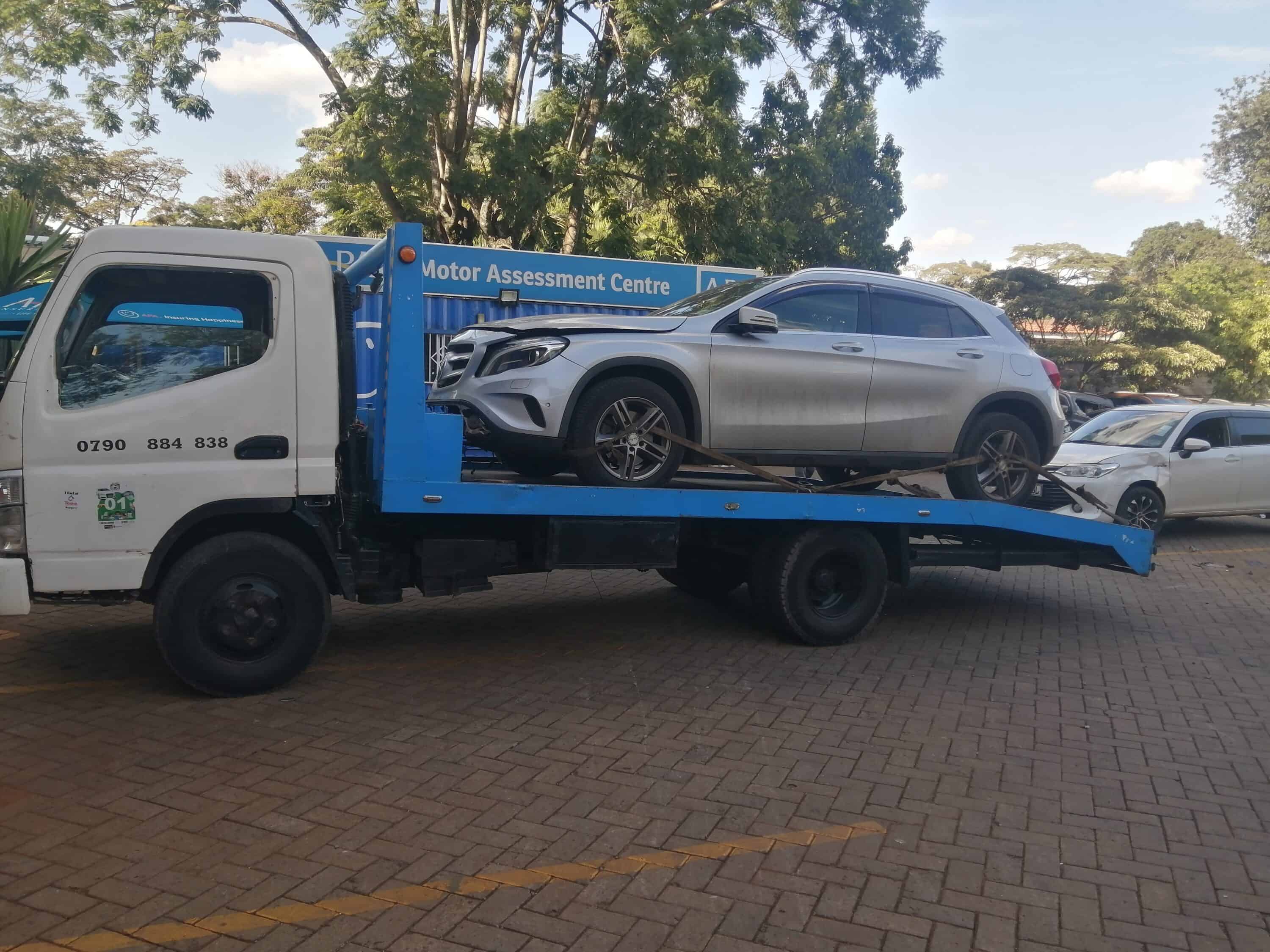 Flatbed tow truck transporting a silver SUV
